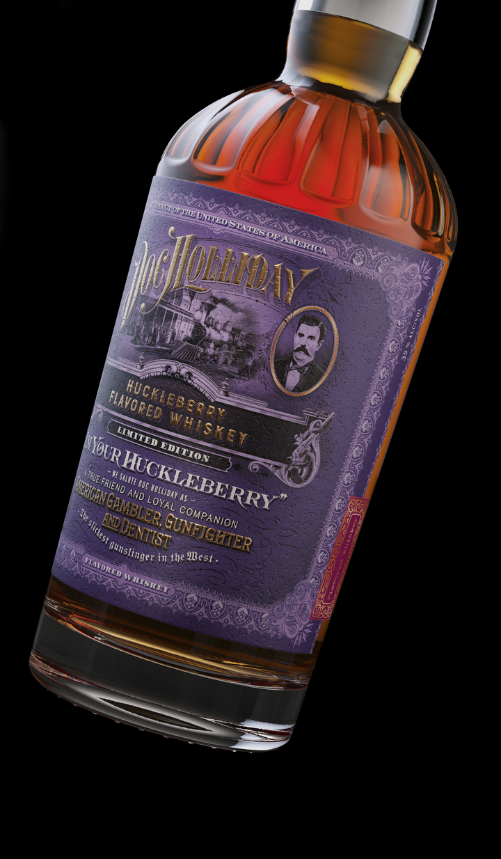 Product photograph of a Doc Holliday Huckleberry Flavored Whiskey bottle with an ornate purple and gold label featuring a vintage steam train and a portrait of Doc Holliday, the amber whiskey visible inside a clear ribbed glass bottle