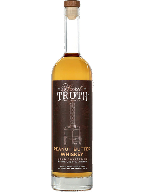 Product photo by Hard Truth Distilling Co. of their Peanut Butter Whiskey bottle, handcrafted in Brown County Indiana, displaying a dark brown label with an illustrated distillation still, golden amber liquid, and a cork stopper